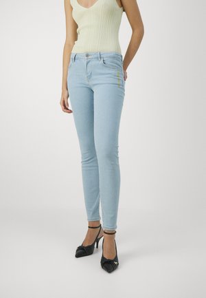Světle modré skinny džíny s jemnou texturou, vybavené zapínáním na knoflík a zip, bočními kapsami a žlutým kontrastním prošíváním.