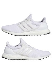 Białe sneakersy Adidas Ultra Boost z plecioną cholewką, trzema teksturowanymi paskami oraz białą amortyzującą podeszwą środkową z czarną gumową podeszwą.