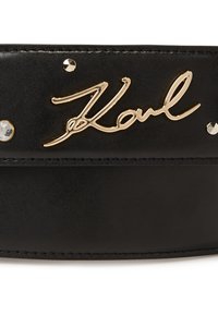 Ceinture en cuir noir avec un logo signature en métal doré et des rhinestones décoratifs, dotée de coutures visibles et d'un design épuré.