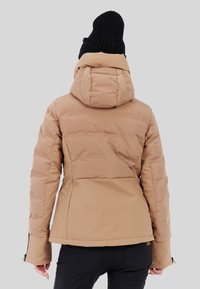 Chaqueta beige acolchada con una silueta ajustada y capucha desmontable, que presenta una textura suave y puños con cremallera para un ajuste mejorado.