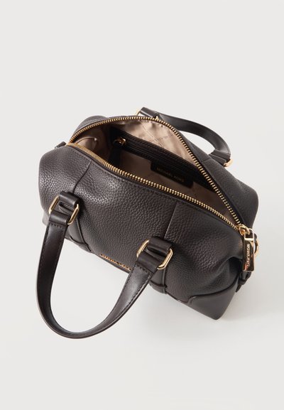 Sac à main Michael Kors en cuir grainé marron foncé ouvert avec fermeture éclair et quincaillerie dorées, montrant une doublure beige et une poche intérieure zippée.