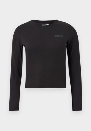 Melnā garām piedurknēm crop top blūze, izgatavota no elastīga auduma, ar apaļu kakla izgriezumu un mazu logotipu drukātu uz krūtīm.