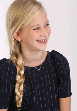 Kind dat een donkerblauwe jurk draagt met witte streepjes, een zilveren hartketting en kleine creolen; lang blond haar in een vlecht.