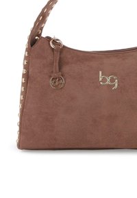 Bolso de ante marrón con el logo dorado "bg", tirador de cremallera dorado y correa adornada con tachuelas doradas, sobre un fondo blanco.