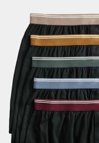 Indumenti in tessuto morbido di vari colori: due neri, uno verde scuro e uno bordeaux, ciascuno con cinture elastiche a contrasto.