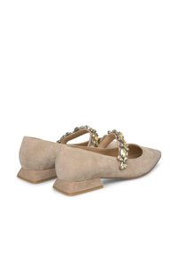 Ballerine in suede beige con punta affilata, un tacco basso texture e una fascia decorativa di gioielli sulla parte superiore del piede.