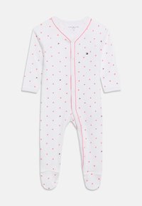 Λευκό βρεφικό φορμάκι με μακριά μανίκια και καλυμμένα ποδαράκια, διακοσμημένο με μικρές ροζ καρδιές, ροζ περιθώριο κατά μήκος των κουμπιών στο μπροστινό μέρος και μικρά ναυτικά λογότυπα.