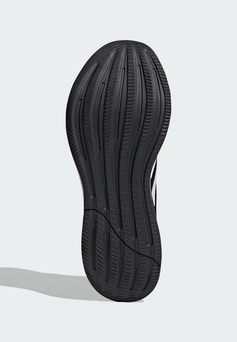 Suela de zapato de goma negra con surcos y relieves texturizados, presentando una silueta curvada y acentos blancos contrastantes a lo largo del costado.