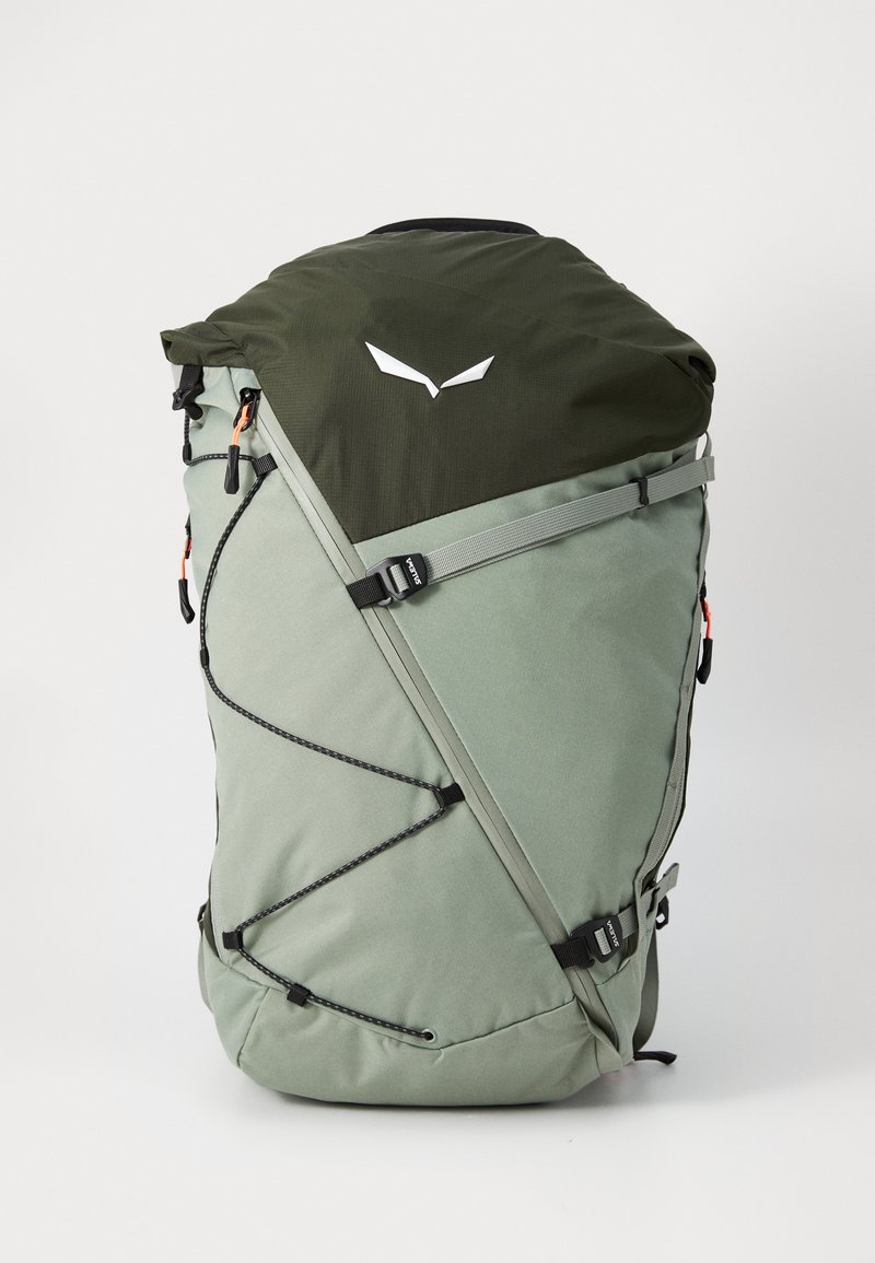 Ryggsekk med mørkegrønn topp og lysegrønn kropp, med en slank form, justerbare stropper, bungee-snorer og detaljer med merkevarelogo.