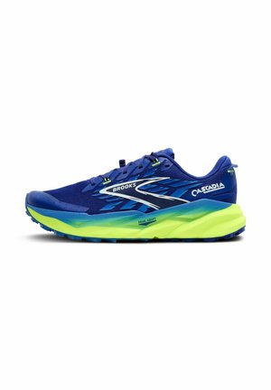 Brooks Cascadia traillöparsko, med en blå ovandel och gröna detaljer, en texturerad sula och en vadderad gul mellansula.