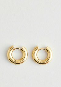 Boucles d'oreilles en or avec un design arrondi et lisse. Présentent une ouverture fendue pour un enfilage facile. La finition brillante accentue l'éclat du métal.