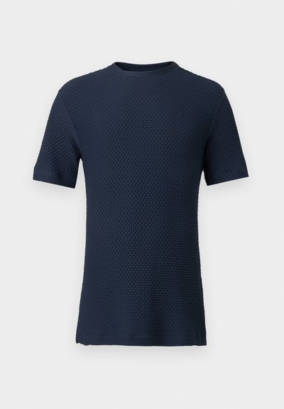 Ανδρικό μπλουζάκι πλεκτό με υφή, σε σκούρο μπλε ναυτικό χρώμα, με κοντά μανίκια και στρογγυλή λαιμόκοψη, σε απλό φόντο.