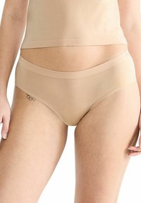 Beige Hipster-Unterwäsche mit glatter Textur, breitem Bund und nahtlosem Design. Der Stoff wirkt dehnbar und enganliegend.