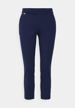 Navy blue pants with a smooth, stretchy fabric. Features a tapered leg design and a simple waistband with a small metallic logo accent.