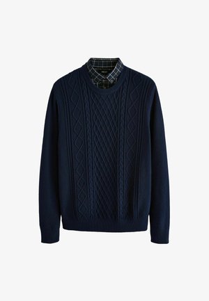 Mornarsko plavi pleteni džemper s kabelskim uzorcima, okruglim izrezom i dugim rukavima. Donji sloj ima karirani uzorak u tamnim tonovima.