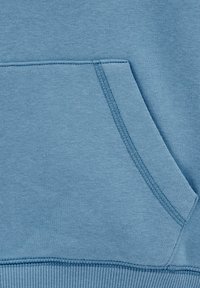 Tessuto di felpa azzurro chiaro con tasca a marsupio e orlo a costine. Texture liscia con dettagli di cucitura visibili sulla tasca e sulle cuciture.