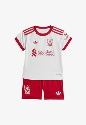 Equipación de fútbol infantil del Liverpool Football Club con camiseta blanca con rayas rojas, logotipos y pantalones cortos rojos con logotipos del club y la marca.