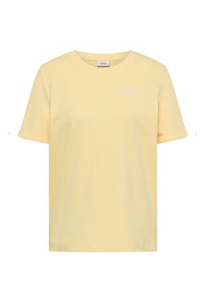 Vaaleankeltainen lyhythihainen T-paita pyöreällä pääntiellä, vasemmassa rinnassa pieni valkoinen logo ja käännetyt hihansuut.