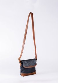 Crossbody bag with a navy upper, brown leather accents, a textured flap with a magnetic snap, and a reinforced shoulder strap.