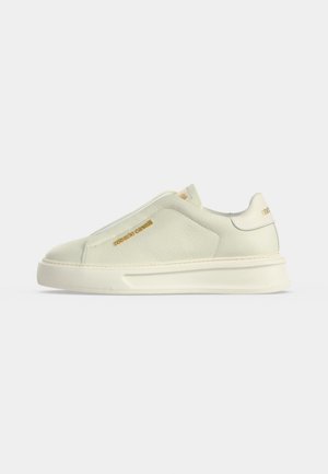 Baskets blanches sans lacets en cuir texturé, semelle épaisse et marquage doré "roberto cavalli" sur le côté et la languette de talon.