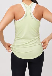 Miętowa sportowa koszulka bez rękawów z plecieniem w kształcie wyścigu i białymi detalami. Wykonana z lekkiego materiału, ma luźny krój i gładką fakturę.