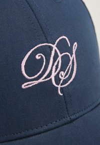 Granatowa czapka z wygiętym daszkiem, z różowym haftowanym logo. Materiał wydaje się gładki, z widocznymi detalami ściegów.