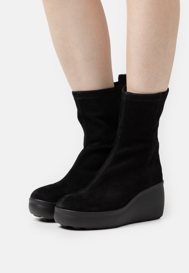 Czarne zamszowe botki na koturnie z gładką fakturą i zapięciem na zamek, z okrągłym noskiem i grubą podeszwą.