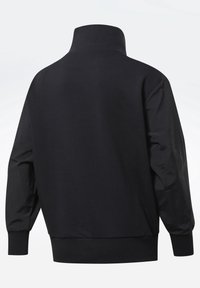 Sudadera negra con un collar alto y mangas largas y texturizadas. Los puños y el dobladillo son de canalé y presentan un acabado de algodón suave.