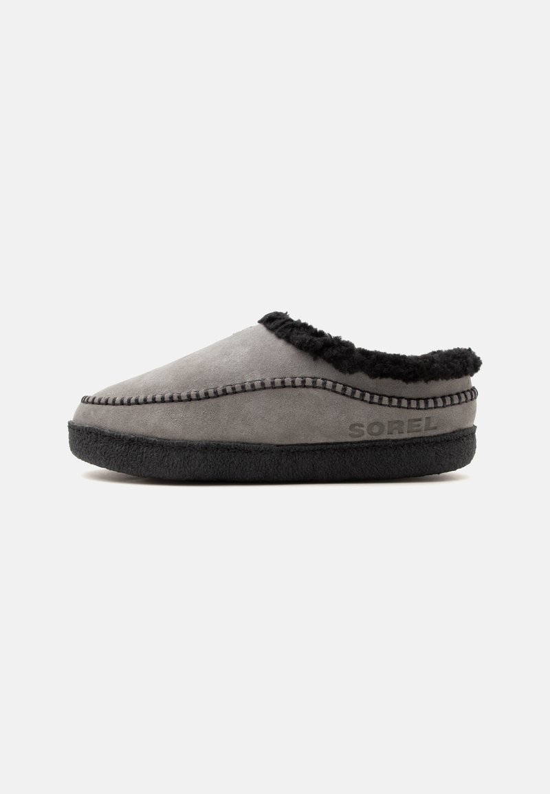 Chausson en daim gris à enfiler avec doublure noire duveteuse, semelle noire et coutures apparentes, marqué avec "SOREL" sur le côté.