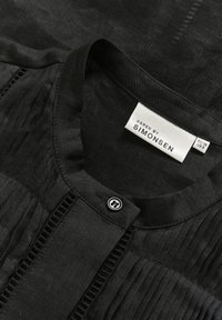 Black blouse with a round collar, featuring vertical pleats and a button closure. Label reads "KAREN BY SIMONSEN," EU size 38, US size 8.