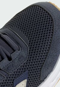 Granatowe siateczkowe sneakersy z teksturowaną cholewką, kontrastującymi akcentami z zamszu, płaskimi sznurowadłami oraz gumową podeszwą o naturalnym wykończeniu.