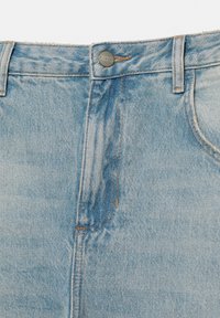 Lyseblå denimjeans med synlig knap mærket "Pull&Bear", bæltestropper og syninger på forlommerne.