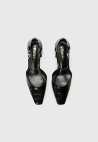 Schwarze Slingback-Absätze mit einem spitzen Fuß, strukturiertem Krokodil-Design und einem kleinen goldenen Akzent an der Seite. Markennamen sichtbar.