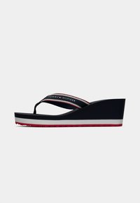 Platform flip-flop in navy with a rubber sole, white midsole, and red accents. Features a fabric strap with "TOMMY HILFIGER" logo.