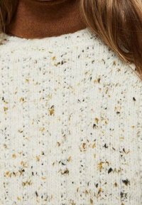 Strickpullover in Creme mit einem strukturierten Muster, das braune und schwarze Einschlüsse aufweist. Rundhalsausschnitt und eine lockere Passform.
