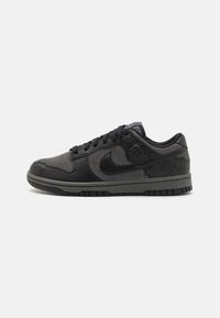 Fekete Nike Dunk Low sneakers, sima bőr és velúr anyaggal, fűzős kialakítással, dombornyomott virágmintákkal, valamint tapadós gumitalppal.
