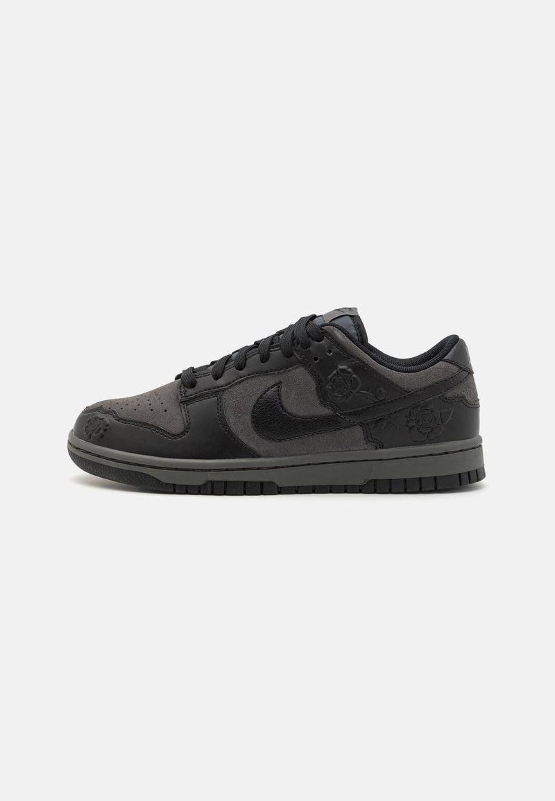 Fekete Nike Dunk Low sneakers, sima bőr és velúr anyaggal, fűzős kialakítással, dombornyomott virágmintákkal, valamint tapadós gumitalppal.