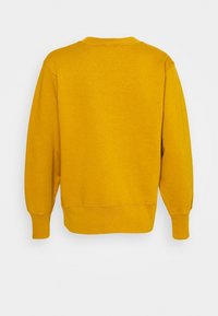 Sudadera amarilla con cuello redondo, mangas largas, puños y dobladillo acanalados. Confeccionada con un material suave, con una textura lisa sin patrones.