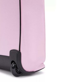 Valigia rigida di colore rosa pallido con accenti neri, caratterizzata da una superficie liscia, angoli arrotondati e una singola ruota alla base per facilitarne il movimento.