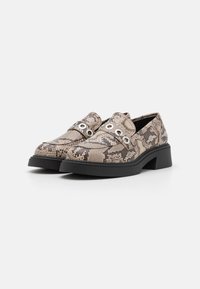 Scarpe con stampa serpente con tacco basso nero a blocco, dotate di occhietti metallici e superficie texturizzata, progettate con punta arrotondata e stile slip-on.