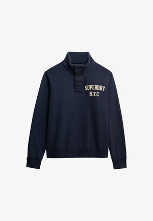 Mørkeblå sweatshirt med funnel neck, tre knapper og "SUPERDRY N.Y.C." trykt i cremefarve på brystet. Blødt stof, lange ærmer.