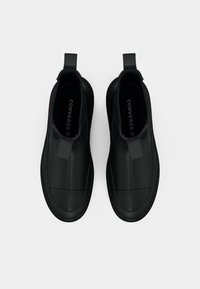Pantofi negri slip-on din piele texturată, cu vârf rotunjit, panouri laterale elastice și talpă plată din cauciuc.