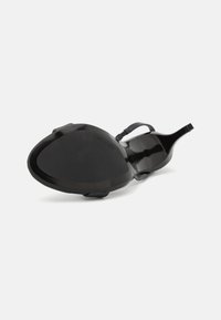 Sandal nero con tacco, con una tomaia lucida e liscia, una sottile cinghia e una suola sagomata. Design minimalista senza motivi o accenti visibili.