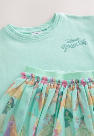 Šviesiai žalias trumpomis rankovėmis megztukas su raukiniu, raštuotu tiulio sijonu, kuriame pavaizduotos Disnėjaus princesės. Ribotas kaklo iškirpimas, atspausdintas užrašas „Disney Princess“.