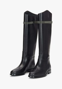 Černé kožené vysoké boty až ke kolenům s hladkou texturou, čtveratou špičkou, kontrastním zeleným páskem a nízkým plochým podpatkem.