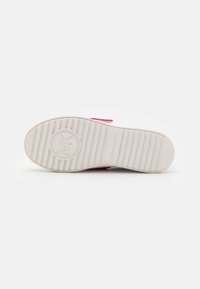 Suola di sneaker bianca con accenti rosa, caratterizzata da una texture rigata e un logo in rilievo. Finitura liscia con un design imbottito per il comfort.