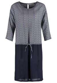 Robe bleue avec haut à motifs, manches trois-quarts, encolure ronde avec boucle de bouton et jupe unie avec un lien noué à l'avant à la taille.