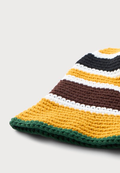 Crocheted beanie with horizontal stripes in green, mustard yellow, white, brown, and black on a white background.