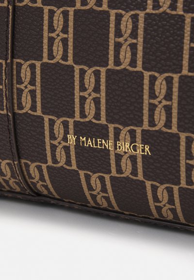 Brown textured material with a geometric pattern. Printed logo in gold: "BY MALENE BIRGER." Rectangular shape, sleek design.