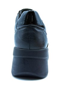 Sneaker in pelle nera con un accento nero lucido sul tallone, forma arrotondata e suola testurizzata, progettata per comfort e supporto.